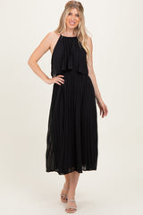 woman wearing a black pleated halter neck midi dress with a layered bodice and sandals