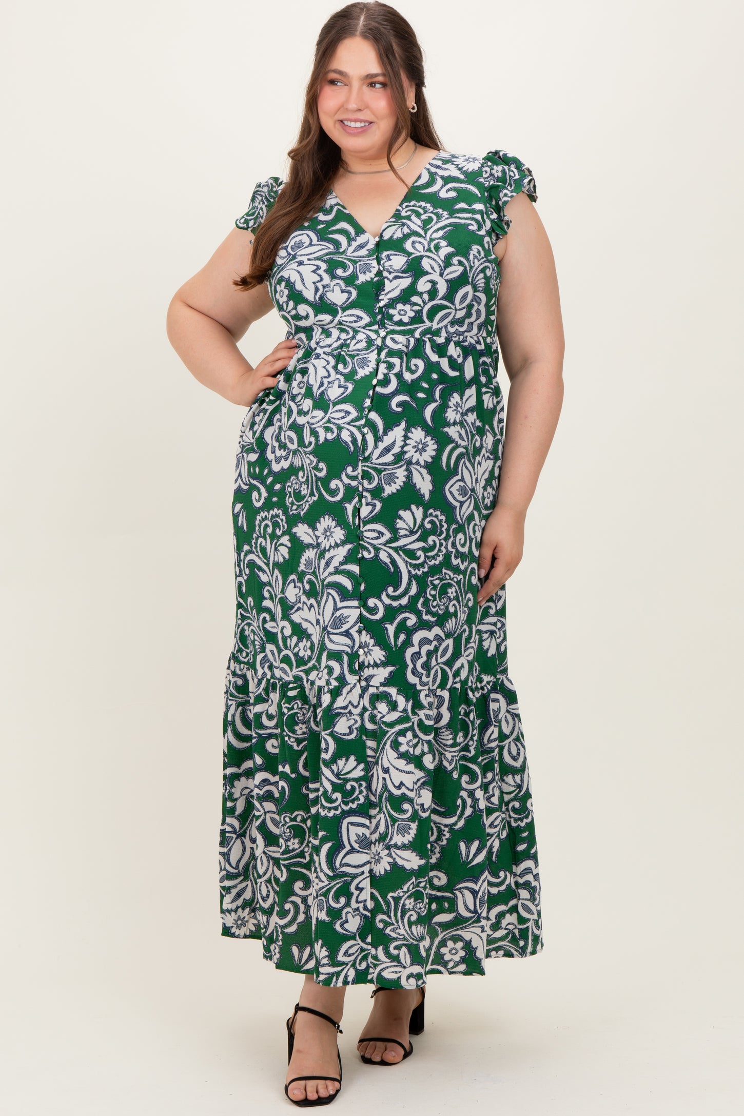 woman in a green and white floral patterned maternity dress with ruffled sleeves and a maxi length