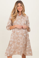 woman wearing a beige floral print maternity dress with a button-down front and three-quarter sleeves