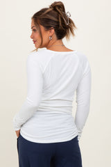 woman wearing a white long sleeve maternity top, showing the back view with a fitted silhouette and soft fabric