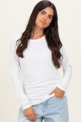woman wearing a white long sleeve top with a relaxed fit and gathered sleeve details