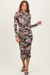 woman wearing a floral print long sleeve bodycon dress with ruching details and a midi length