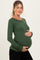 woman wearing a dark green long sleeve maternity top and holding her baby bump