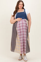 woman wearing a patchwork maternity plus maxi dress with denim top and plaid bottom, holding her baby bump
