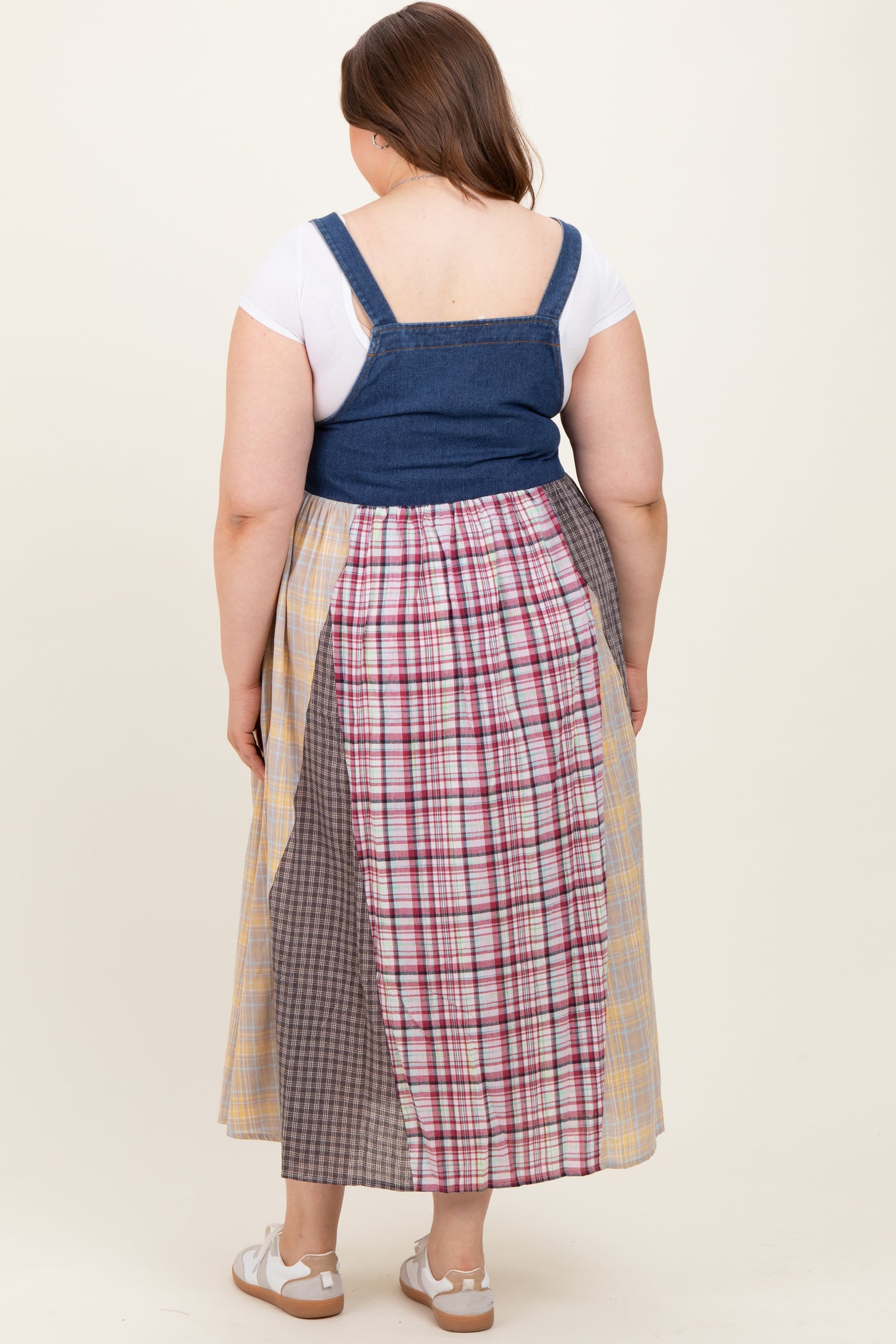 woman wearing a maternity plus size patchwork maxi skirt with a denim bodice and side split, showing the back view