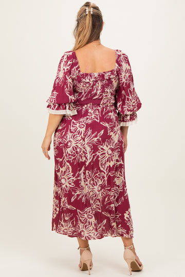 woman wearing a burgundy floral print maternity dress with puffed sleeves and a square neckline, showing a baby bump