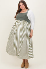 woman wearing a green and white striped maternity plus dress with a fitted top and flowy skirt, showing her baby bump