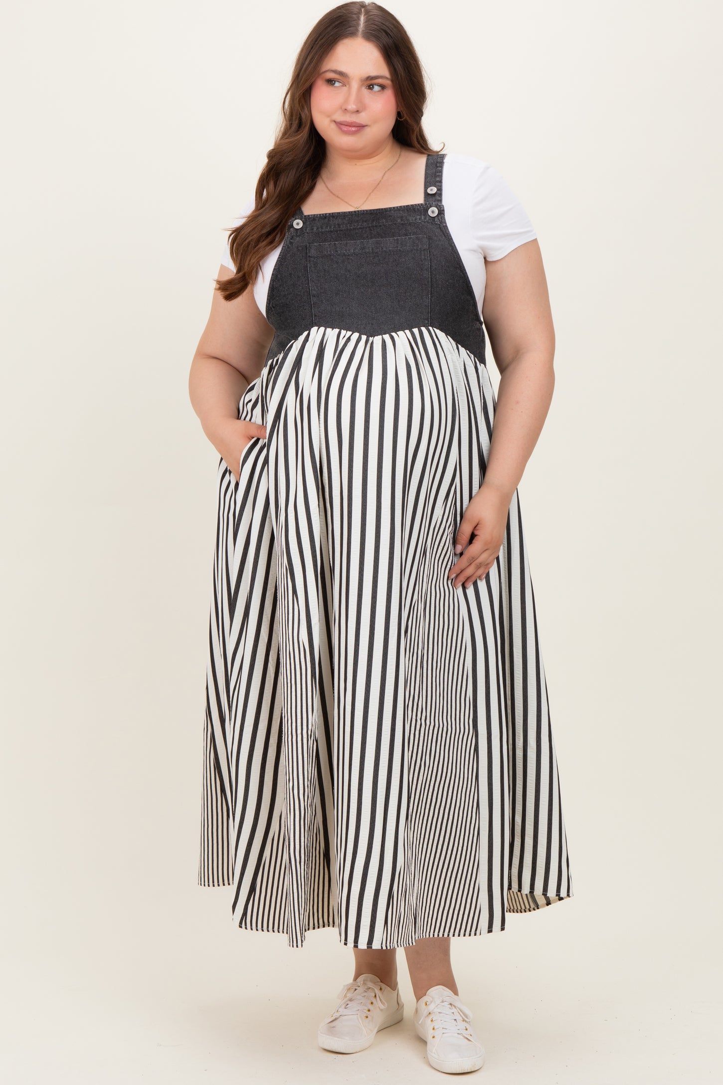 woman wearing a black and white striped maternity maxi dress with a denim-style bodice and a baby bump