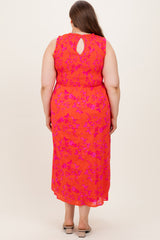 woman wearing a coral pink maternity plus dress with a floral pattern and keyhole back detail, shown from the back