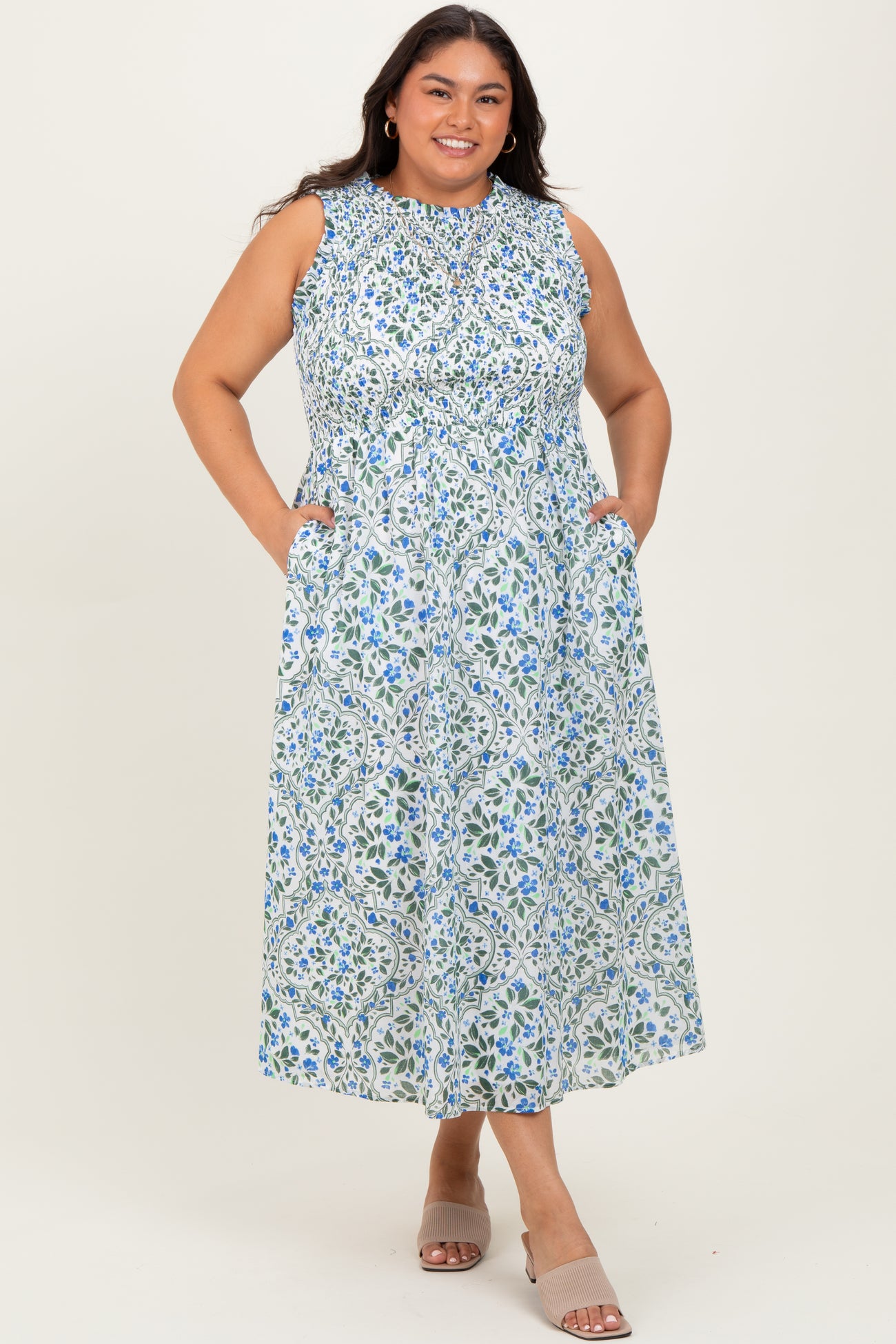 woman wearing a sleeveless floral plus-size maxi dress with pockets and a high neckline