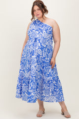 woman wearing a blue and white floral one-shoulder maternity plus dress with a tiered skirt and a flowing silhouette