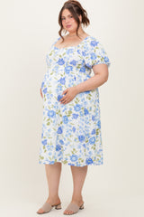 woman wearing a floral print maternity plus dress with short puff sleeves and holding her baby bump