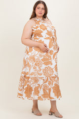woman wearing a white and orange floral maternity dress with a tiered skirt and holding her baby bump