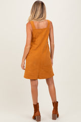 woman wearing a mustard corduroy maternity dress with a fitted bodice and flared skirt, viewed from the back