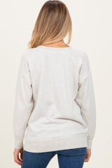 woman wearing a light gray maternity sweater with a relaxed fit, seen from the back with long sleeves