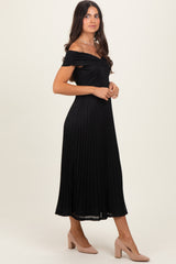woman wearing a black off-the-shoulder pleated midi dress and nude heels