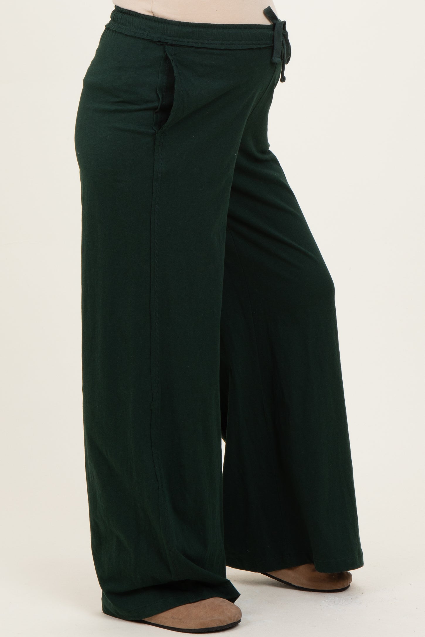 maternity wear in dark green wide-leg pants with a drawstring waist and side pockets