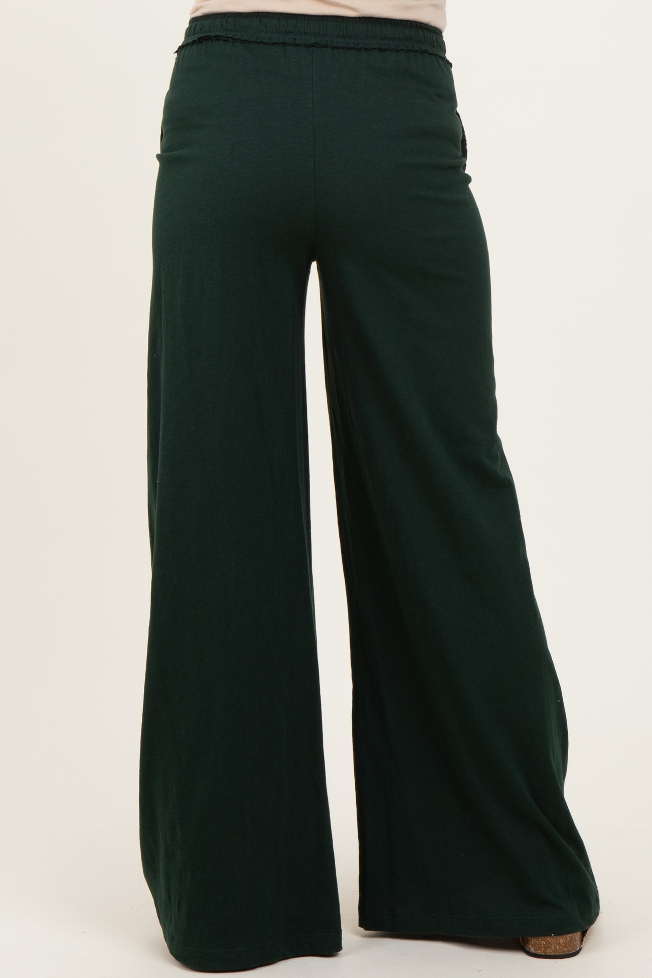 woman wearing green maternity wide-leg pants with an elastic waistband, showing the back view