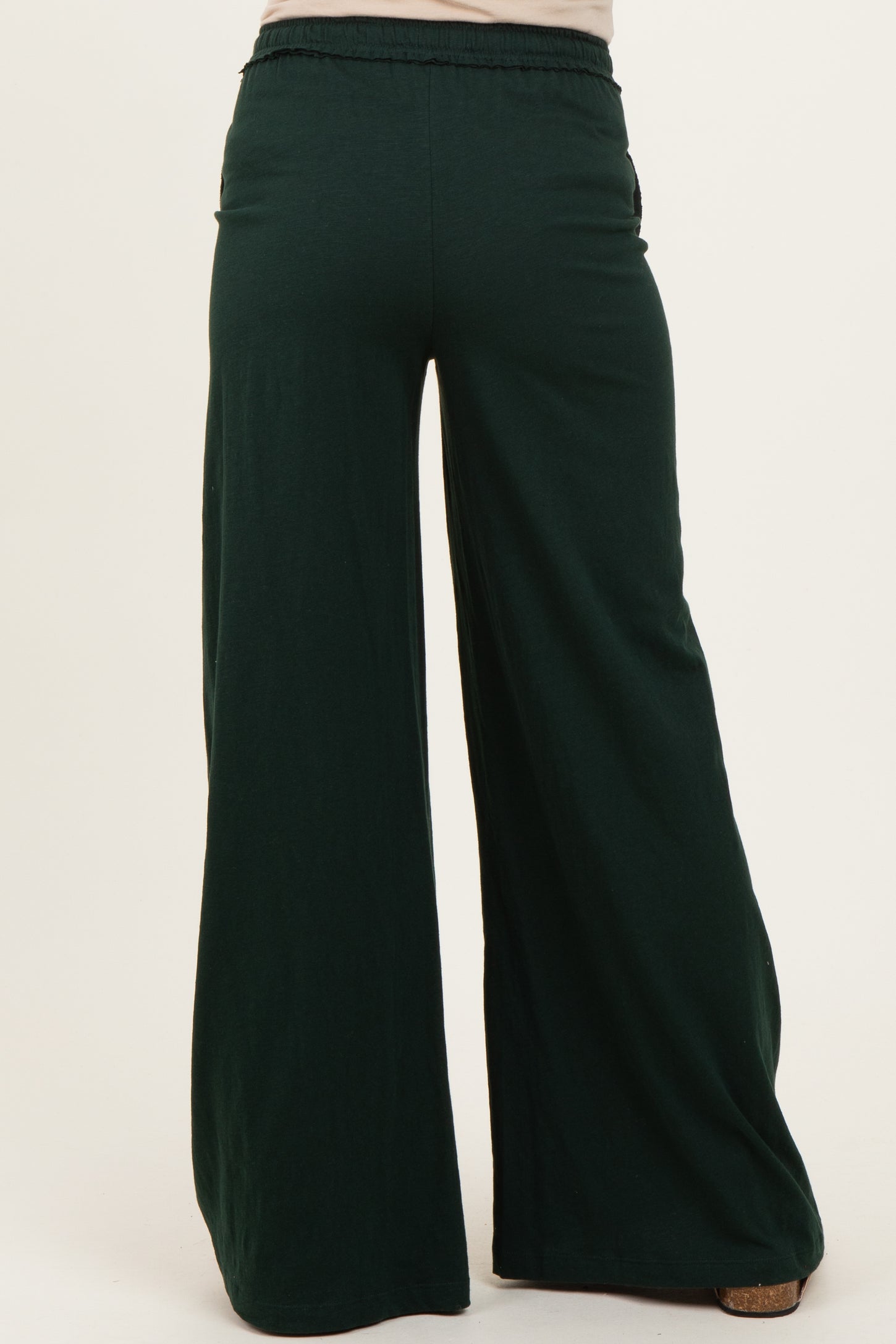 woman wearing green maternity wide-leg pants with an elastic waistband, showing the back view