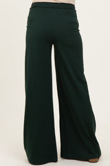 woman wearing green maternity wide-leg pants with an elastic waistband, showing the back view