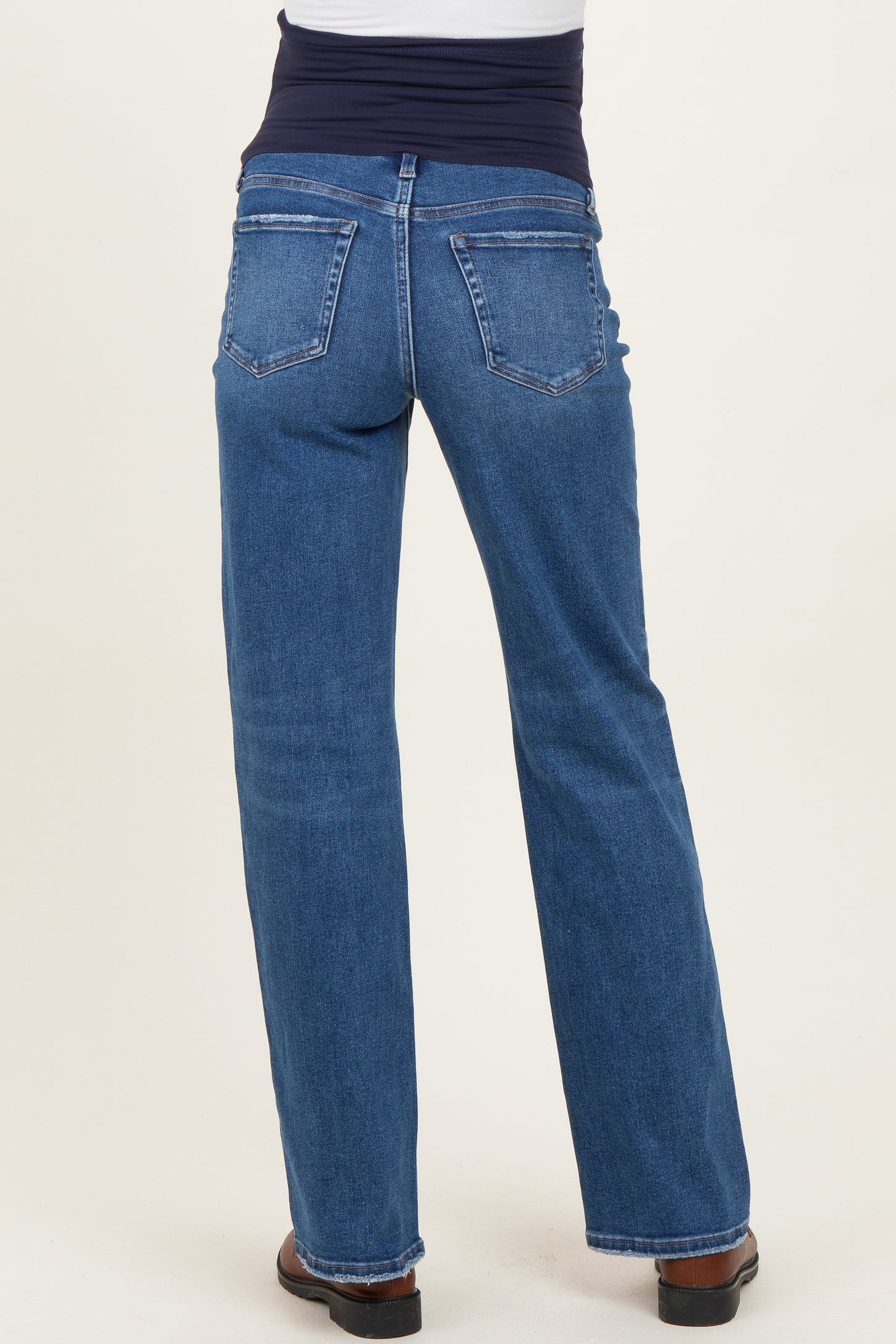 woman wearing maternity blue straight leg jeans with a stretchy black waistband viewed from the back