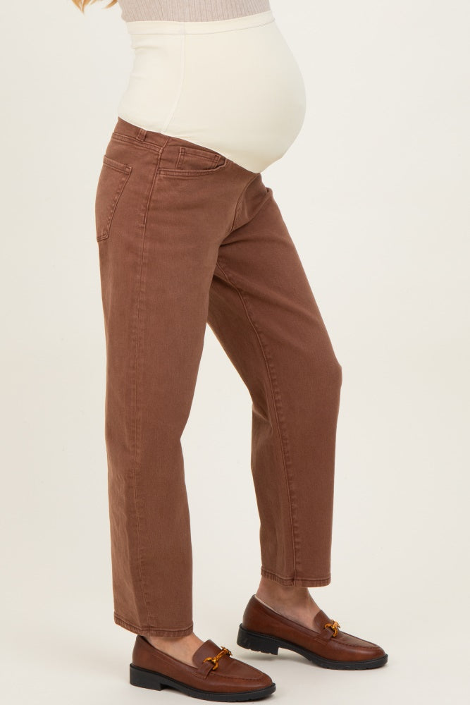 woman wearing brown maternity jeans with a supportive over-the-bump waistband and a visible baby bump