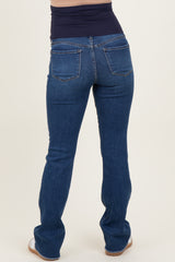 woman wearing dark blue maternity jeans with a low-rise waistband, showing the back view and a fitted style