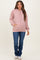 woman wearing a pink ribbed maternity hoodie with front pockets and jeans