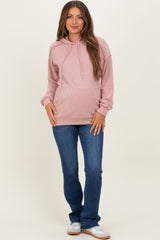 woman wearing a pink ribbed maternity hoodie with a relaxed fit and jeans, showcasing her baby bump