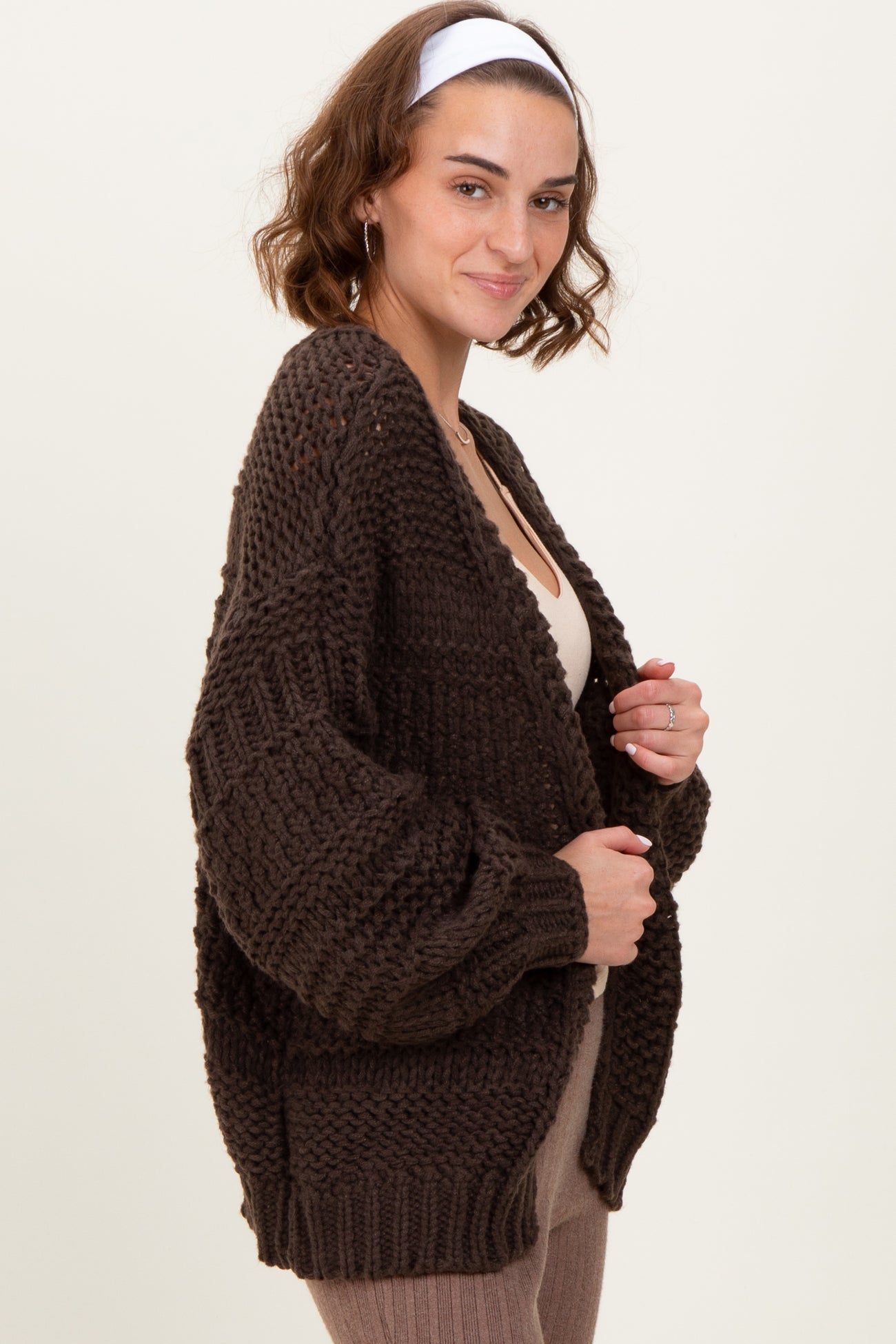 woman wearing a dark brown oversized knitted cardigan with a relaxed fit and loose sleeves