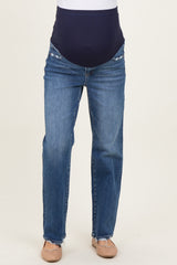 woman wearing a pair of blue maternity jeans with a dark blue over-the-bump waistband and distressed details