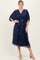 woman wearing a navy blue floral lace midi dress with a v-neck and short sleeves