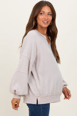 woman wearing a light gray ribbed maternity top with balloon sleeves, showing a visible baby bump