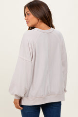 woman wearing a soft pink oversized maternity sweater with balloon sleeves and a relaxed fit, view from the back