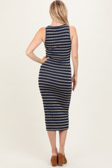 woman wearing a navy and white striped bodycon midi dress with a scoop back and brown block heel sandals