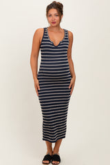 woman wearing a navy and white striped maternity maxi dress with a deep v-neck, standing straight and smiling