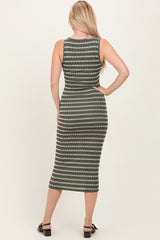 woman wearing a fitted green and white striped midi dress, showing the back view with long hair down