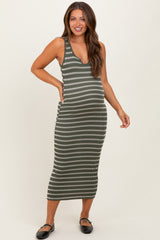 woman wearing a green and white striped maternity dress with a fitted silhouette and a scoop neckline, showcasing her baby bump