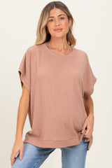 woman wearing a dusty rose oversized ribbed maternity top with short sleeves and a relaxed fit