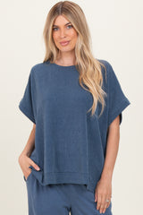 woman wearing a navy blue ribbed short sleeve top with a relaxed fit and side pockets