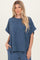 woman wearing a navy blue ribbed short sleeve top with a relaxed fit and side pockets