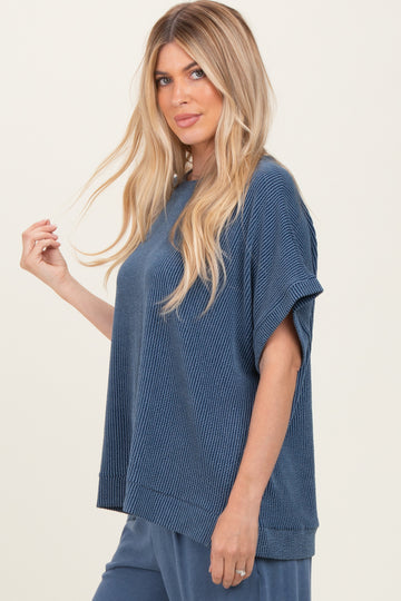 woman wearing a loose-fitting navy blue textured top with short sleeves and a casual style