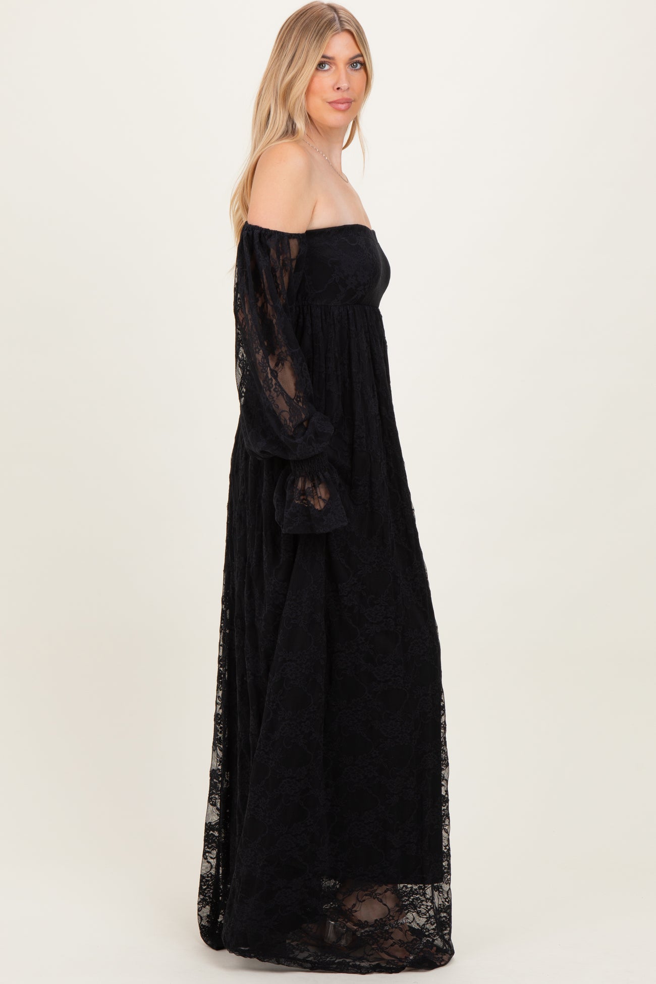woman wearing a black off-the-shoulder lace maxi dress with long puff sleeves
