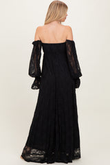 woman wearing a black off-shoulder lace maxi dress with long, puffed sleeves, shown from the back