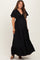 woman wearing a black maternity maxi dress with short sleeves and a tie front detail, featuring a visible baby bump