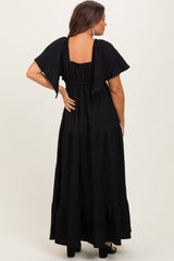 woman wearing a black maternity maxi dress with short flutter sleeves and tiered ruffle details, back view