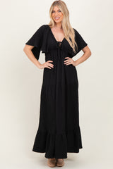 woman wearing a black maxi dress with short sleeves and a tie front detail, styled with a tiered skirt