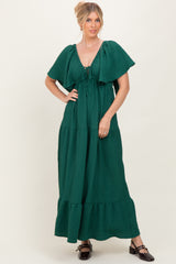 woman wearing a dark green tiered maxi dress with short ruffle sleeves and a tie detail at the neckline