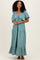 woman wearing a teal tiered maxi dress with flutter sleeves and a drawstring neckline