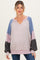 woman wearing a multicolored striped oversized maternity sweater with a v-neckline and balloon sleeves